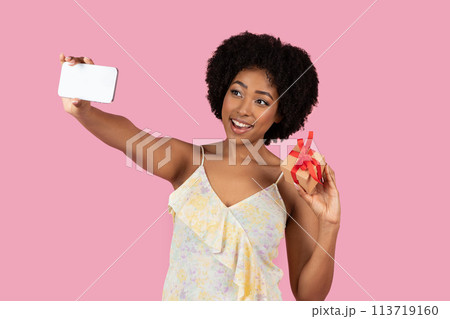 Selfie-taking woman with phone and small red box Selfie-taking woman with phone and small red box 113719160