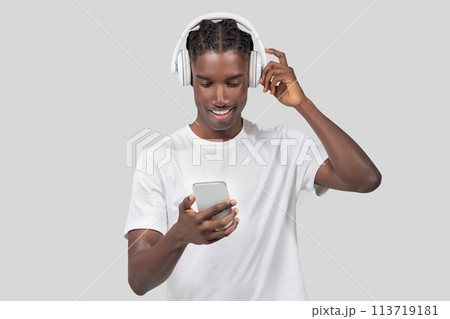 Young man enjoying music on headphones on white background Young man enjoying music on headphones on white background 113719181