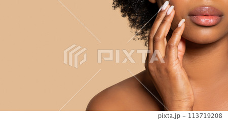 Closeup of black woman's lips and hand, beige background, free space Closeup of black woman's lips and hand, beige background, free space 113719208