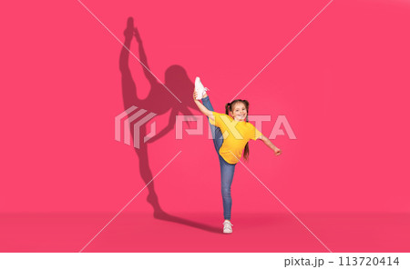 A joyful young girl in a yellow shirt and jeans performs a high leg kick with enthusiasm A joyful young girl in a yellow shirt and jeans performs a high leg kick with enthusiasm 113720414