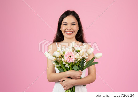 Close-up of woman embracing floral bouquet on pink background Close-up of woman embracing floral bouquet on pink background 113720524
