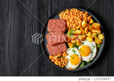corned beef, baked beans, potatoes and fried eggs 113720937