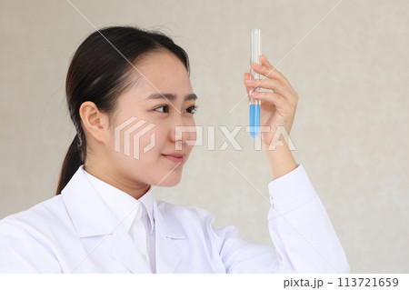 嬉しそうな表情で試験管を見る白衣の女性 嬉しそうな表情で試験管を見る白衣の女性 113721659