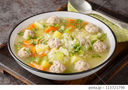 Hot homemade Rice Meatball Soup with celery, carrots, onions and potatoes close-up in a bowl. Horizontal Hot homemade Rice Meatball Soup with celery, carrots, onions and potatoes close-up in a bowl. Horizontal 113721790