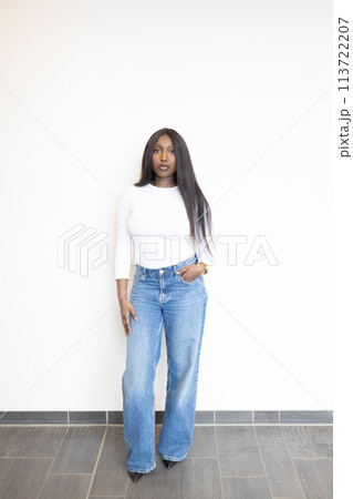 Modern Casual Style: Young Woman in White Top and Denim Jeans 113722207