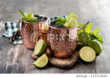 Moscow mule cocktail served with ice and lime slice on wooden table Moscow mule cocktail served with ice and lime slice on wooden table 113723834
