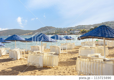 Empty beach loungers without people in start or the end of summer vacation season 113723890