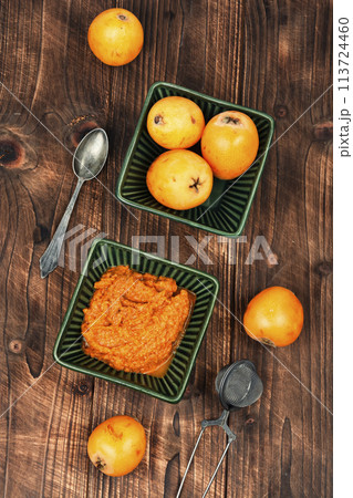 Medlar fruit sauce on wooden table. 113724460
