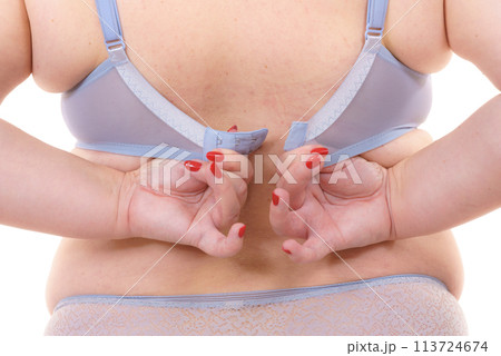 Woman back view putting on her bra lingerie. 113724674