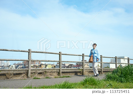 土手を歩く女性 土手を歩く女性 113725451