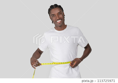 Man using a tape measure on his waist Man using a tape measure on his waist 113725971