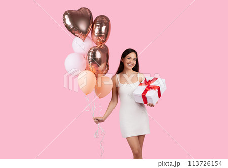 Lady in white dress with balloons and gift 113726154