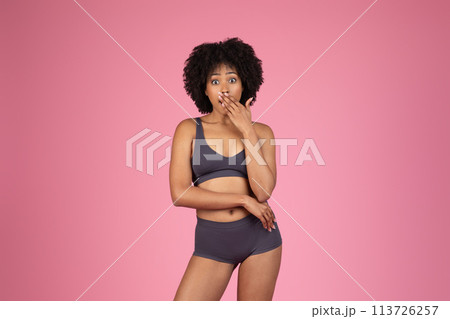 Surprised woman in sportswear covering mouth 113726257