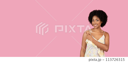 Smiling African American woman pointing to her left Smiling African American woman pointing to her left 113726315