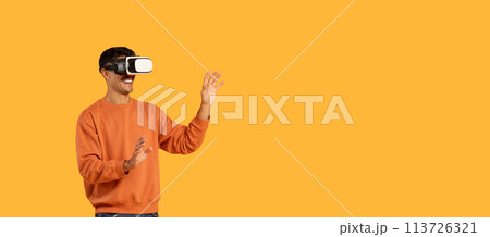 Guy engaging with virtual reality, wearing a VR headset 113726321