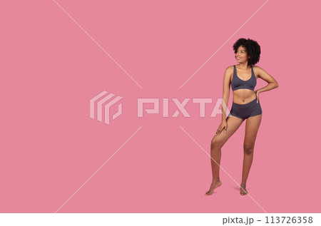 Standing African American lady in sportswear on pink background Standing African American lady in sportswear on pink background 113726358