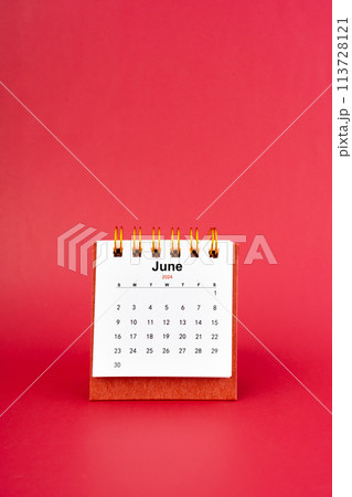 June 2024 white mini desk calendar on red background. June 2024 white mini desk calendar on red background. 113728121