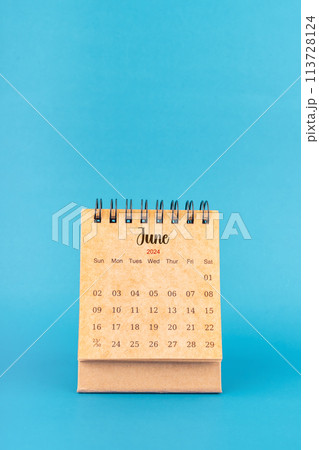 June 2024 white desk calendar on blue color. June 2024 white desk calendar on blue color. 113728124