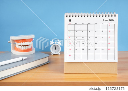 June monthly desk calendar for 2024 year and model dentures on the table. June monthly desk calendar for 2024 year and model dentures on the table. 113728173