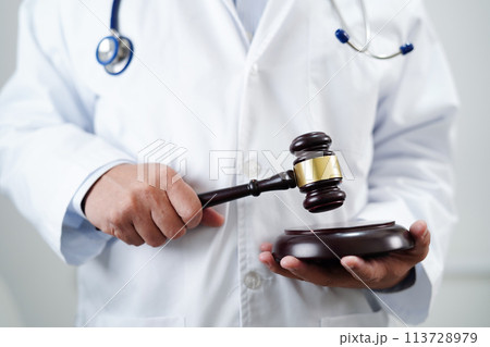 Asian doctor holding court hammer for and crime law justice, forensic medicine. Asian doctor holding court hammer for and crime law justice, forensic medicine. 113728979