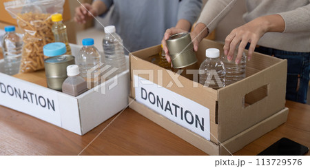 Volunteer preparing free foodstuff rations for poor people. Charity two woman of the community work together. concept of giving and humanitarian aid 113729576