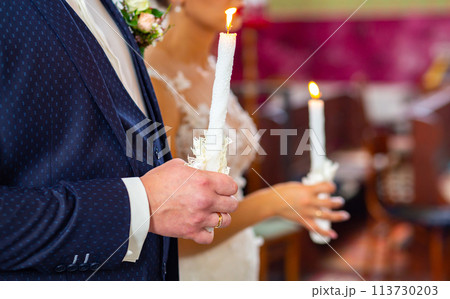 Bride and groom holding the candles. Close up. Bride and groom holding the candles. Close up. 113730203