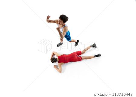 Top view. Two male wrestling athletes in blue and red uniform, showing victory and defeat isolated on white background 113730448
