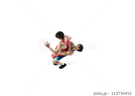 Top view. Wrestlers in action, two male athletes wrestling, training isolated on white background Top view. Wrestlers in action, two male athletes wrestling, training isolated on white background 113730452