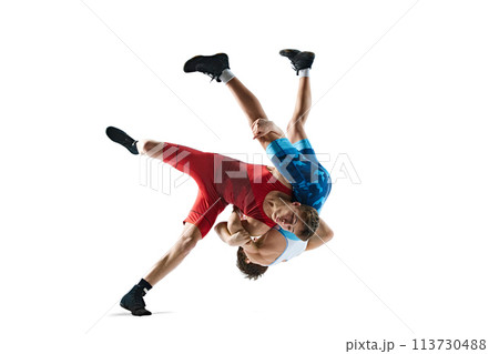 Two greco-roman wrestlers in red and blue uniform wrestling isolated on white background. Competitive young men 113730488