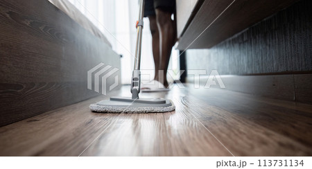 African American man young wash the floor with a mop in the room at home African American man young wash the floor with a mop in the room at home 113731134