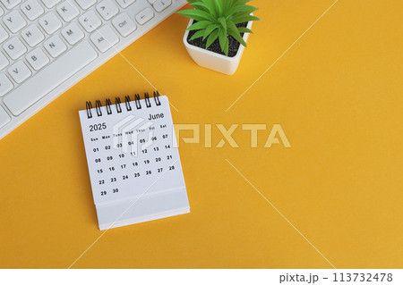 June 2025 desk calendar on yellow background. Directly above. Flat lay. 113732478