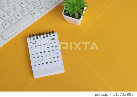 May 2025 desk calendar on yellow background. Directly above. Flat lay. May 2025 desk calendar on yellow background. Directly above. Flat lay. 113732805