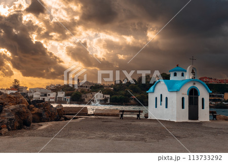 Beautiful chapel on the coast on Crete on rays of sunrise. 113733292