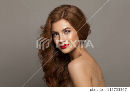 Glamorous fashionable redhead woman with long wavy hair and make-up. Studio headshot portrait Glamorous fashionable redhead woman with long wavy hair and make-up. Studio headshot portrait 113733567