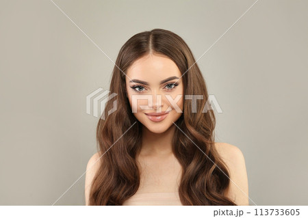 Gorgeous young female model with healthy hair, makeup and shiny clear skin posing  113733605