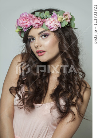 Stylish brunette woman with fresh flower on her head. Spring, cosmetic 113733721