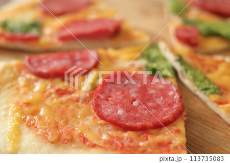 Unhealthy snack. Fast food nutrition. Closeup of delicious pizza with salami 113735083