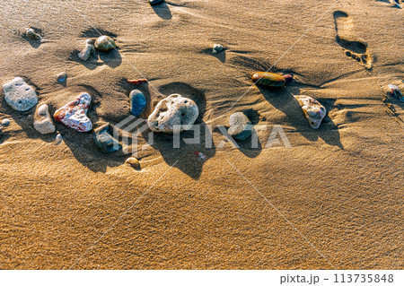 sea sand and stones on the beach at sunset sea sand and stones on the beach at sunset 113735848