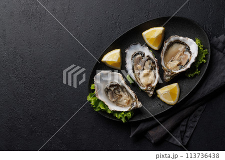 Fresh oysters with lemon on plate Fresh oysters with lemon on plate 113736438