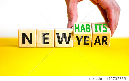 New year and habits symbol. Concept word New year New habits on wooden cubes. Beautiful yellow table white background. Psychologist hand. Psychological new year and habits concept. Copy space. 113737226