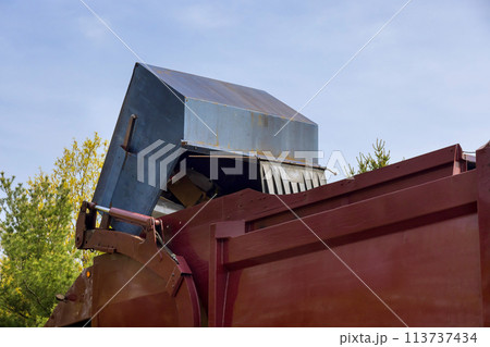 Suburban garbage disposal service truck a trash can into a garbage truck. 113737434