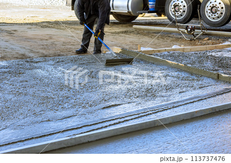 During construction of a new house driveway, wet cement has been poured concrete During construction of a new house driveway, wet cement has been poured concrete 113737476