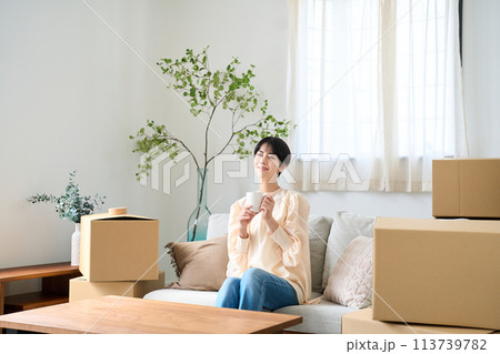 引越しの荷物に囲まれる女性 引越しの荷物に囲まれる女性 113739782