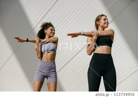 Smiling women does warm-up exercises in morning before running training outside. Healthy fitness Smiling women does warm-up exercises in morning before running training outside. Healthy fitness 113739950