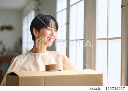 ダンボール箱を運ぶ女性 113739967