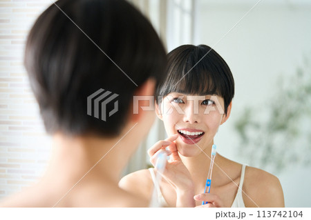 洗面台で歯磨きする女性 洗面台で歯磨きする女性 113742104