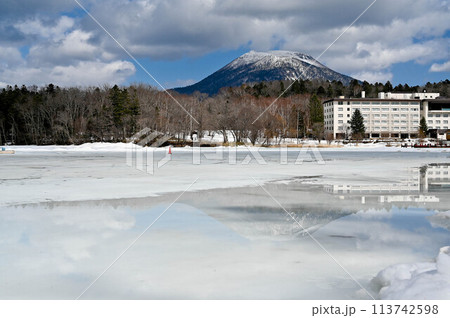 春先の氷結した阿寒湖と雄阿寒岳 氷が少し溶けた湖面 春先の氷結した阿寒湖と雄阿寒岳 氷が少し溶けた湖面 113742598