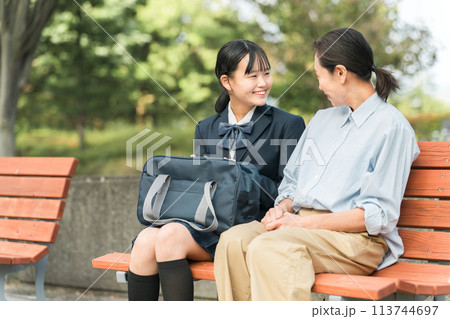 公園のベンチで笑顔で会話する女性・親子・母娘・中学生・教師・先生 113744697