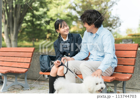 公園のベンチに座る犬の散歩をする愛犬家の親子・娘・父親 113744703