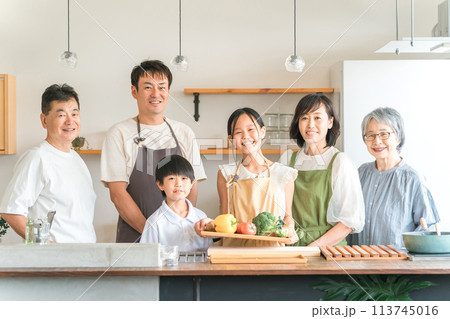 家のキッチンで子供と一緒に料理・クッキングする三世代家族・夫婦・親子（野菜・健康・栄養） 113745016